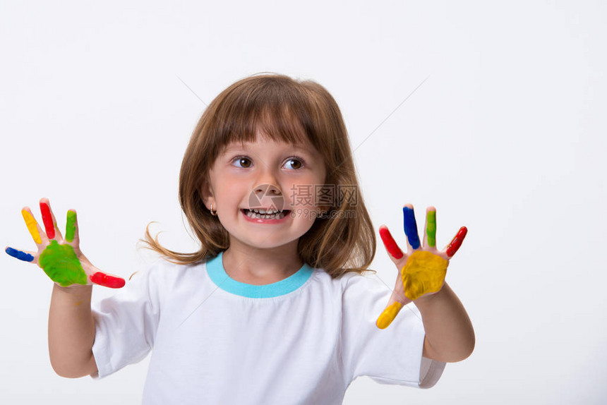 快乐的笑容美丽的小女孩带着她多彩的双手在白背景图片