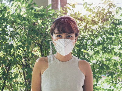 美丽的亚洲妇女穿着白色保护N95防尘面具图片