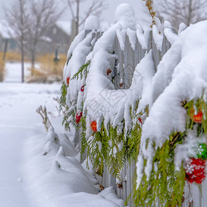 犹他州下雪天用节日花环围起来的栅栏图片