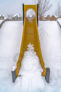 冬季充满活力的滑梯与粉雪交相辉映充满活力的黄色滑梯在冬天覆盖在斜坡上的粉状白雪黎明时分背景图片