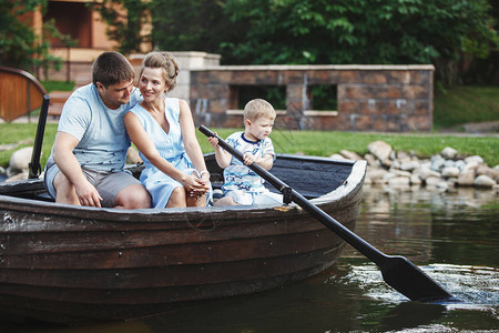 家庭坐在木船上有桨的木船图片
