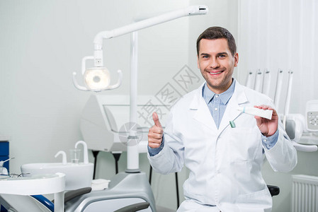 牙医在牙科诊所内持有牙图片