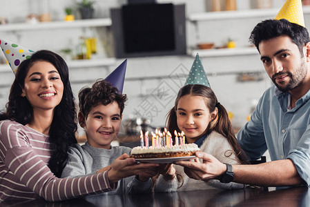 快乐的西班牙家庭拿着生日蛋糕图片