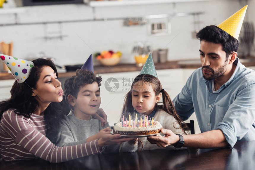 在家生日蛋糕上吹着蜡烛的派对帽使西班牙图片