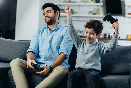 在家和爸玩游戏后把双手举起头来与父亲一图片
