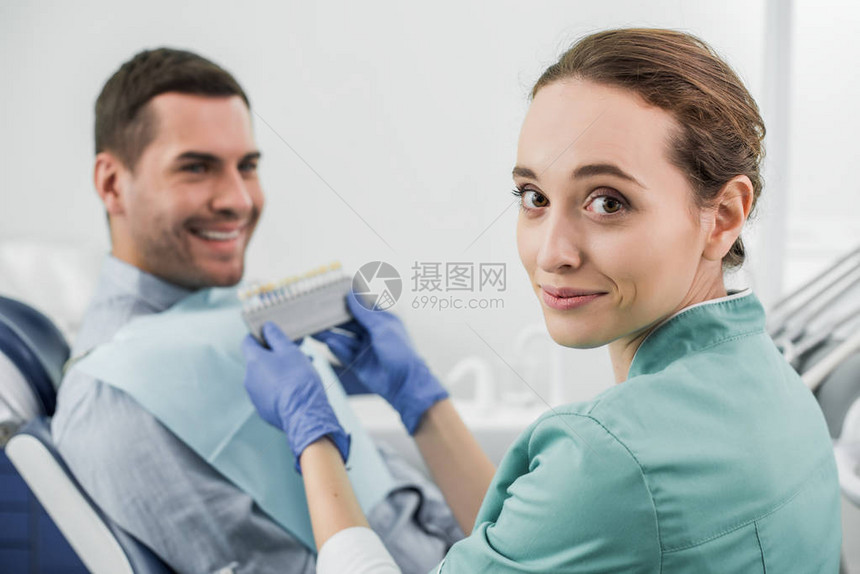 喜悦的牙医有选择焦点在病人附近持图片