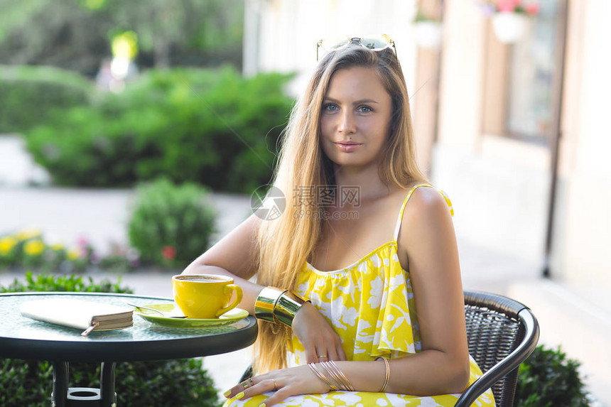 有魅力的女人在自助餐厅穿着黄色连衣裙的年轻女士户外快乐图片