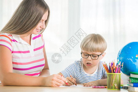 可爱的孩子在家和妈一起学习一家人一起做作业年轻妈帮助她的儿子图片