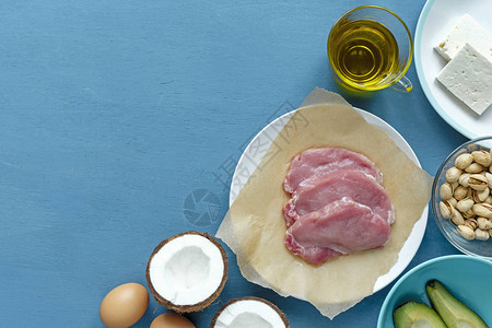 烹饪纸椰子鳄梨鸡蛋油和奶酪三块红肉生牛排图片