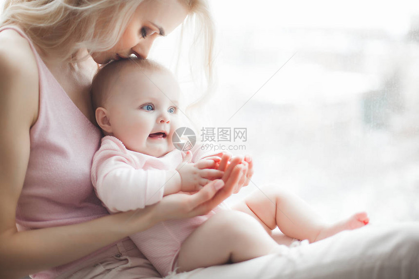 年轻漂亮的妈带着她的小宝在家里妈和女儿在室内月子和她的图片