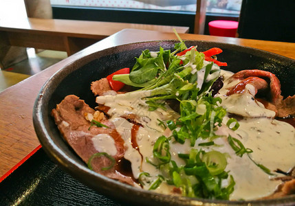 烧烤和切片与意大利白酱汁和沙拉一起在碗里煮熟的日本牛肉Wa图片