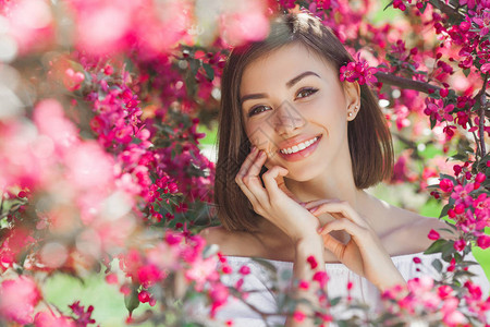 年轻美女的美容肖像鲜花中的迷人女户外图片