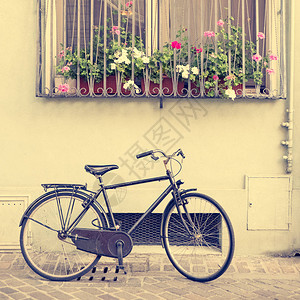 房子附近的老式自行车窗台上有窗户和鲜花图片