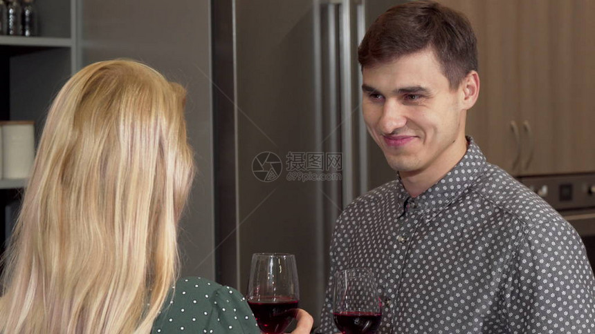 英俊的男人和他的女朋友碰杯庆祝买新房迷人的男人和他的妻子在厨房的新公寓里图片