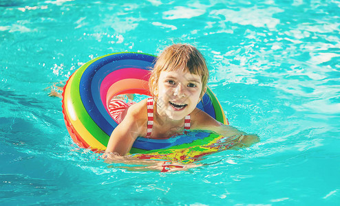 一个孩子在游泳池里游泳图片