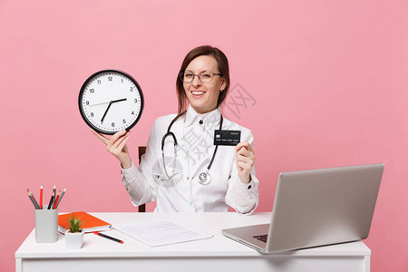 女医生坐在电脑上的办公桌前工作背景图片