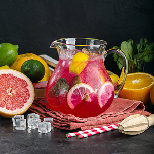 壶里的红柠檬水清凉饮料柑橘类水果深色背景餐厅图片
