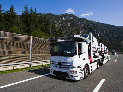 重型运货卡车在夏季日用半拖车运输高速公路上的新车图片