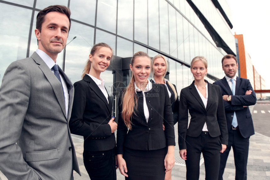 成功商业人员团队在现代办公大楼附近户外站在一起的一图片