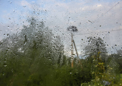 在秋天的雨滴下潮湿的玻璃后面图片