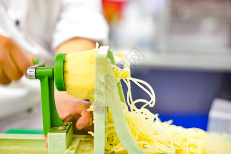 蔬菜刀片螺旋增压器餐桌上有土豆意大利面粉的图片