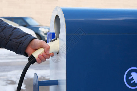 生态友好的运输概念安装在停车场的汽车充电站手拿着电动图片
