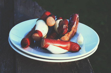 在户外白盘上野餐的香肠图片