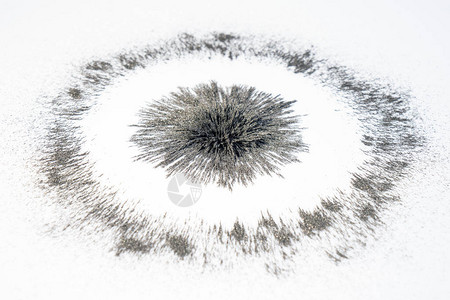 在白色背景上的铁粉磁场下的强圆径向磁学校科学课高清图片