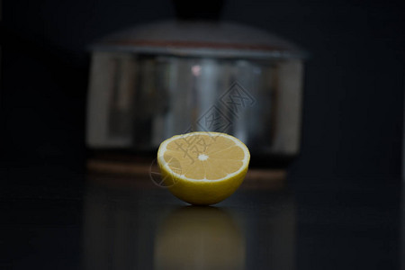 在黑色桌子上将新鲜的黄色柠檬切成两半图片