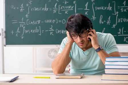 年轻的男学生数学家在黑背景图片