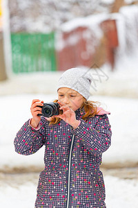 一个女孩在冬天带着摄像头散步背景图片