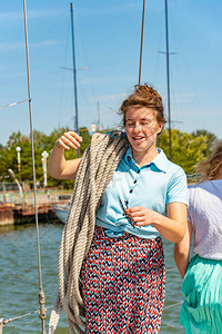 有个女孩在游艇的甲板上挂绳子环望四周肩膀图片