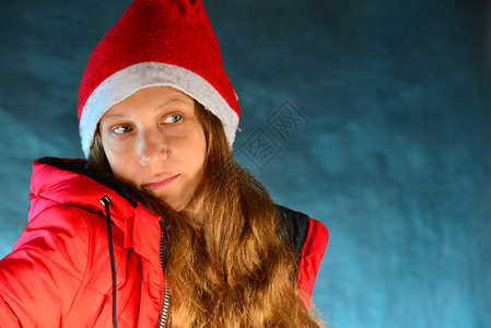 穿着红色夹克和圣诞老人帽子的可爱女孩图片