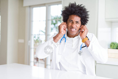 在诊所的非裔美国医生用手指遮住耳朵图片