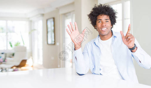 非裔美国人在家里展示和指着七号手指图片