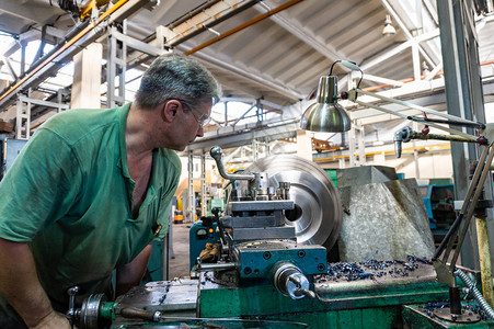 工人一个男子在机器上加工金属产品生背景图片