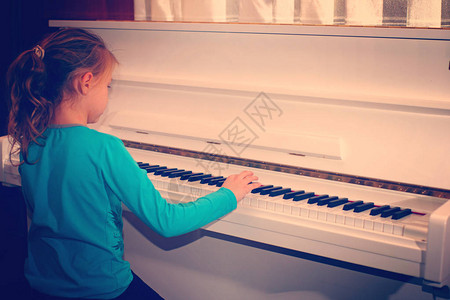 手放在钢琴演奏旋律的白键上图片