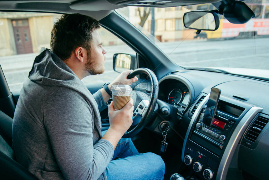 愤怒的男子驾驶汽车喝咖啡交通堵图片