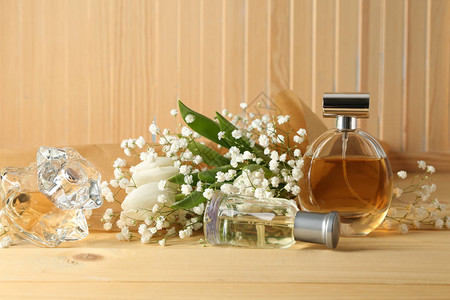 木桌上的香水瓶和鲜花图片