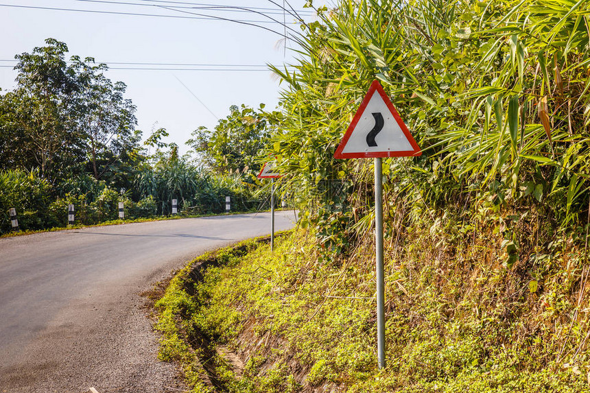 在一条山路上挂起道路的标志警告图片