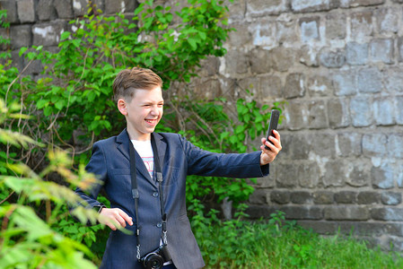 一个男孩拿着相机做自拍在智能手图片