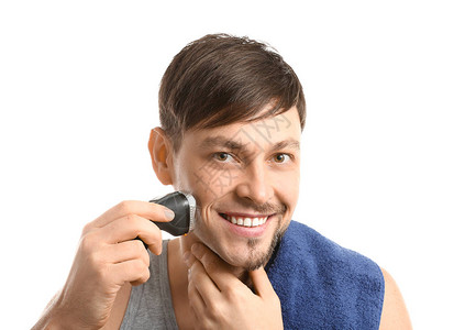 英俊的男人在白色背景下使用电动剃须刀图片