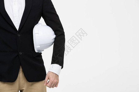 身穿黑色西装的工程师肖像手臂上戴着白头盔站在他身后图片
