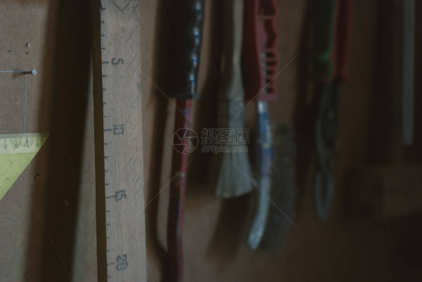自制的木匠尺和挂在谷仓墙上的更多不同的旧工具图片