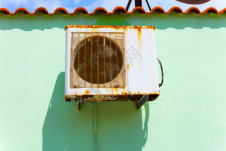 老房子的墙上挂着生锈的旧空调阳光明媚的日子图片
