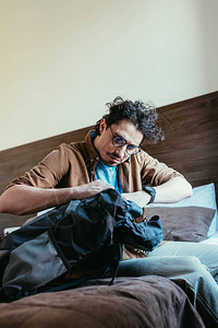 男人用眼镜从旅馆房间的背景图片