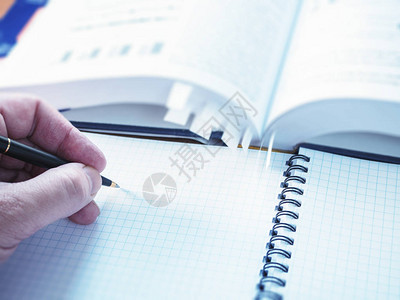 左撇子用笔在记本上写笔记图片