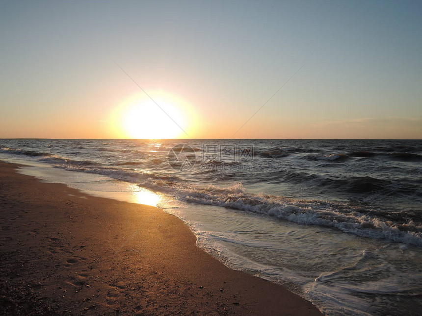柔软的海浪冲刷着的沙滩背景日落图片