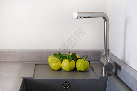 厨房水槽旁边的黄色多汁苹果木瓜厨房间里带水槽的现代柜台图片