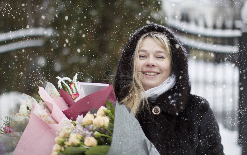 一个快乐女人的肖像花束在雪花背景图片